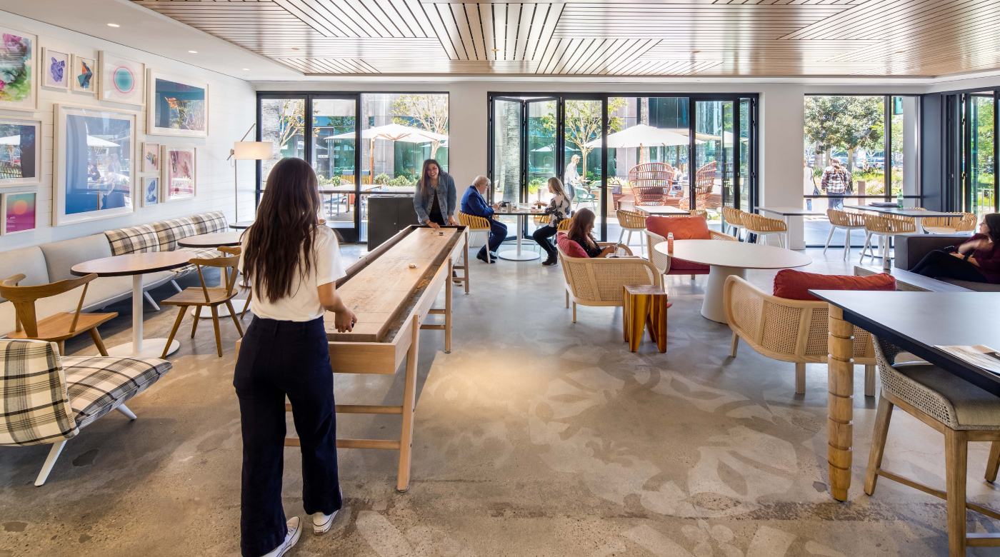 Interior view of lounge space with people relaxing and playing shuffleboard