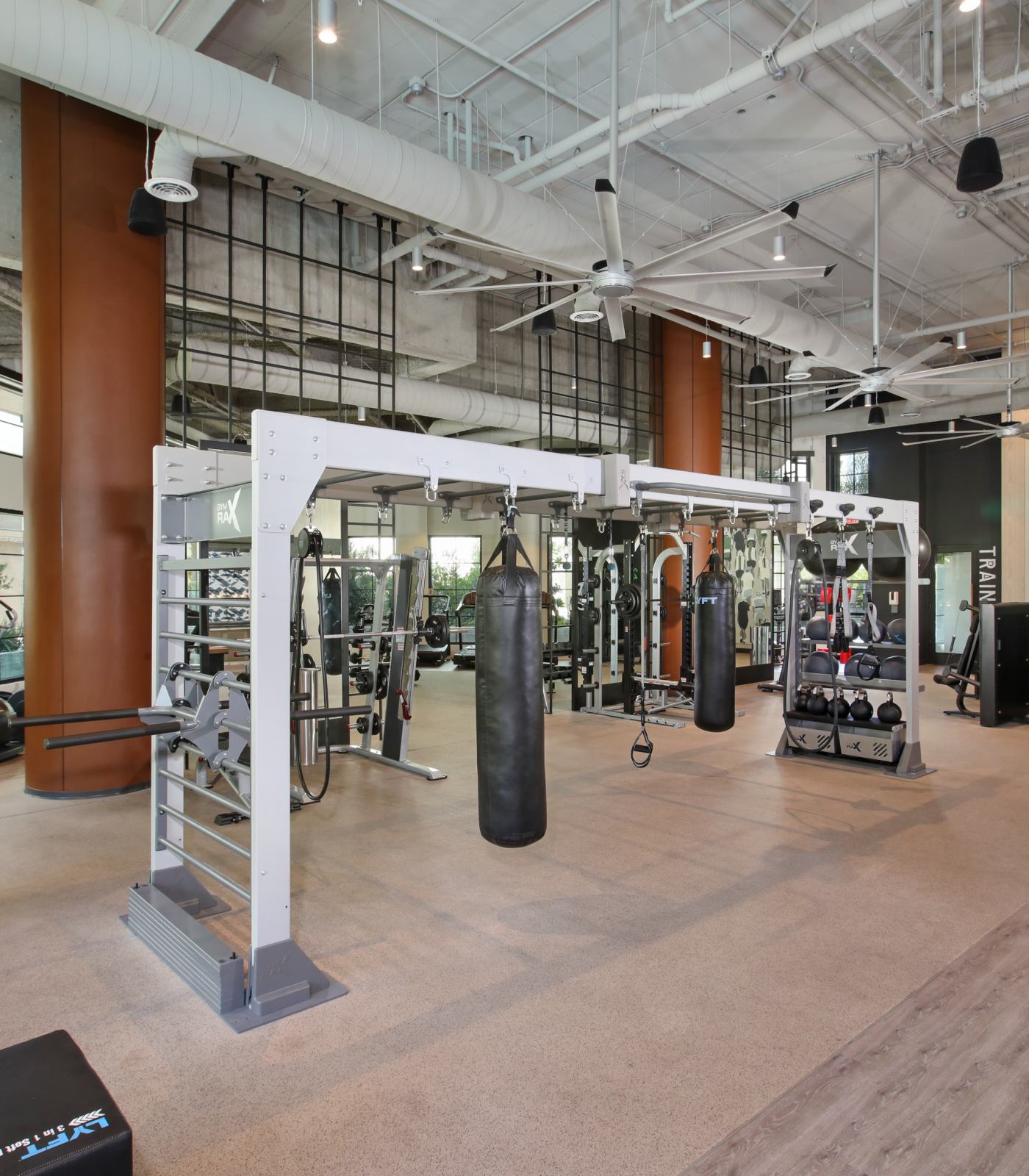 Interior view of a gym with punching bags and workout machines